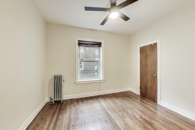 unfurnished room featuring wood-type flooring, radiator, and ceiling fan