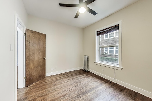 empty room featuring radiator heating unit, ceiling fan, and wood-type flooring