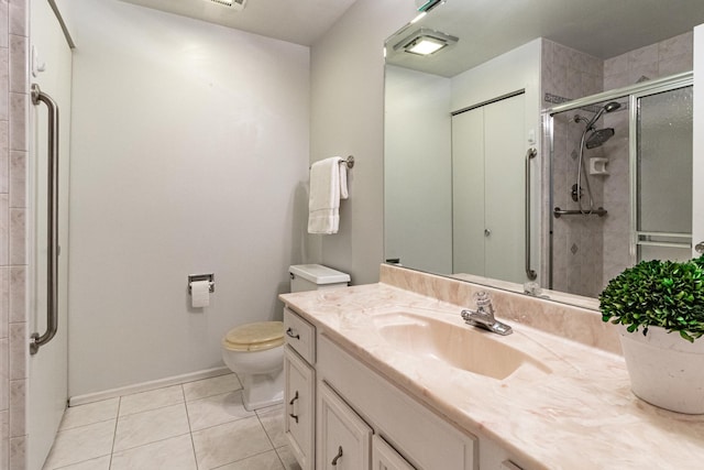 bathroom with tile patterned flooring, vanity, a shower with door, and toilet