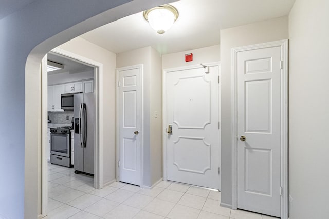 hall featuring light tile patterned flooring