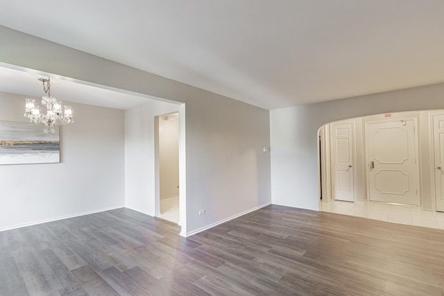 unfurnished room featuring hardwood / wood-style flooring and a notable chandelier