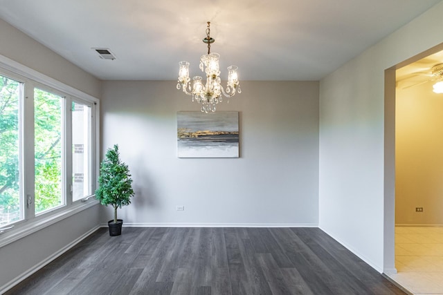 spare room with ceiling fan with notable chandelier and dark hardwood / wood-style floors