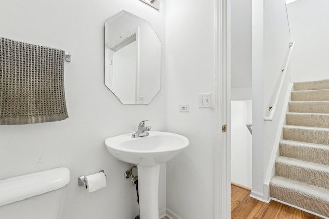 bathroom with wood-type flooring, toilet, and sink