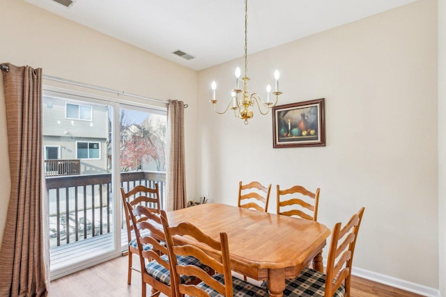 dining space with a notable chandelier and wood-type flooring