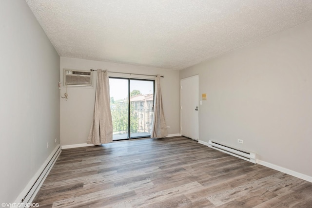 empty room with a textured ceiling, a wall mounted AC, and a baseboard heating unit