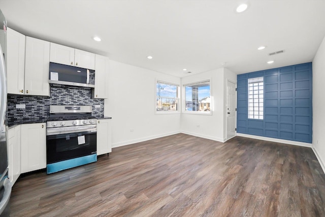 kitchen with white cabinets, decorative backsplash, dark hardwood / wood-style flooring, and stainless steel appliances