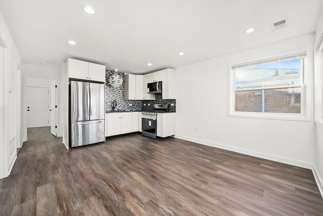 kitchen featuring sink, stainless steel appliances, dark hardwood / wood-style floors, decorative backsplash, and white cabinets