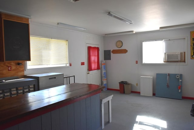 kitchen with butcher block countertops, water heater, and crown molding