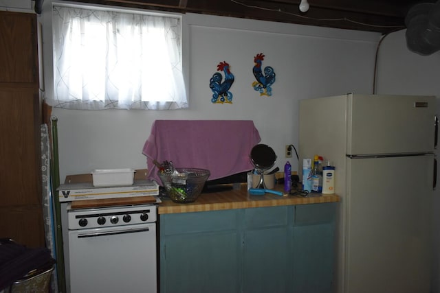 kitchen with butcher block countertops, a healthy amount of sunlight, and white refrigerator