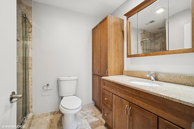 bathroom with a shower with door, vanity, and toilet