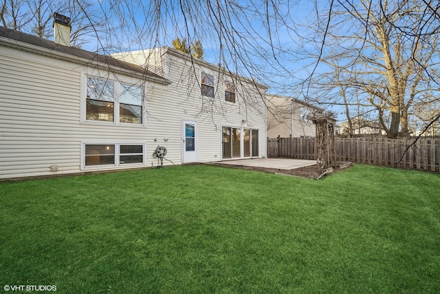 rear view of property with a yard and a patio