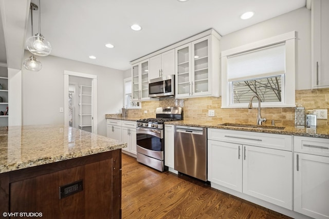 kitchen featuring sink, stainless steel appliances, dark hardwood / wood-style floors, decorative light fixtures, and white cabinets