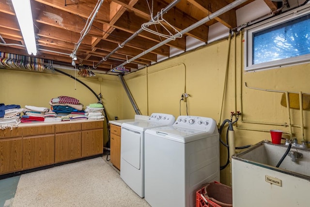 laundry room with washer and dryer, sink, and cabinets