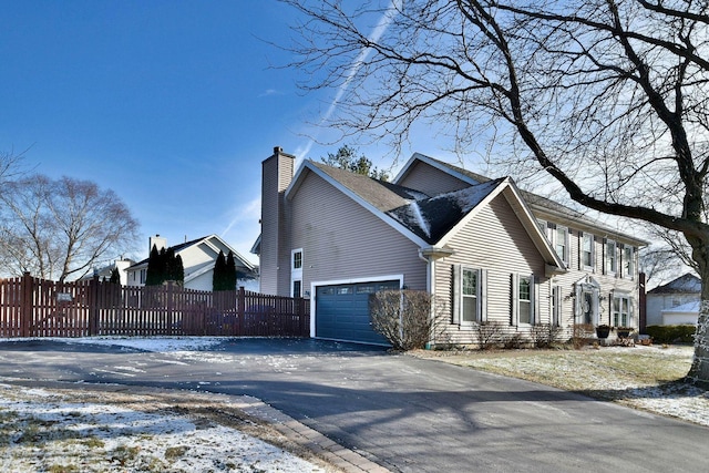 view of snowy exterior featuring a garage