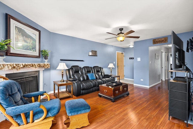 living room featuring ceiling fan and dark wood-type flooring