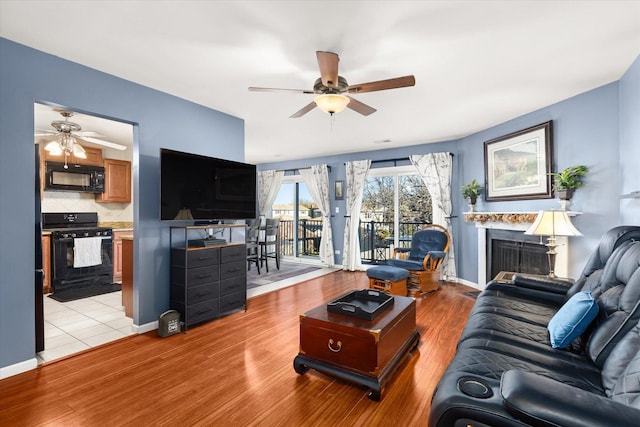 living room featuring ceiling fan and light hardwood / wood-style flooring