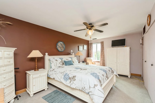 bedroom with ceiling fan, a closet, and light carpet