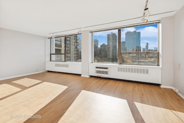 spare room featuring hardwood / wood-style flooring and track lighting