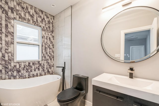 bathroom with vanity, toilet, and a tub