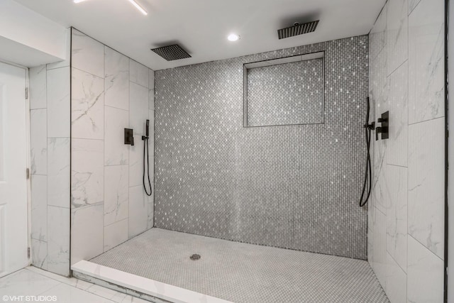 bathroom featuring tile patterned floors and a tile shower