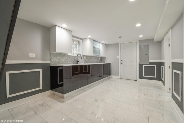 kitchen with white cabinets, tasteful backsplash, kitchen peninsula, and sink