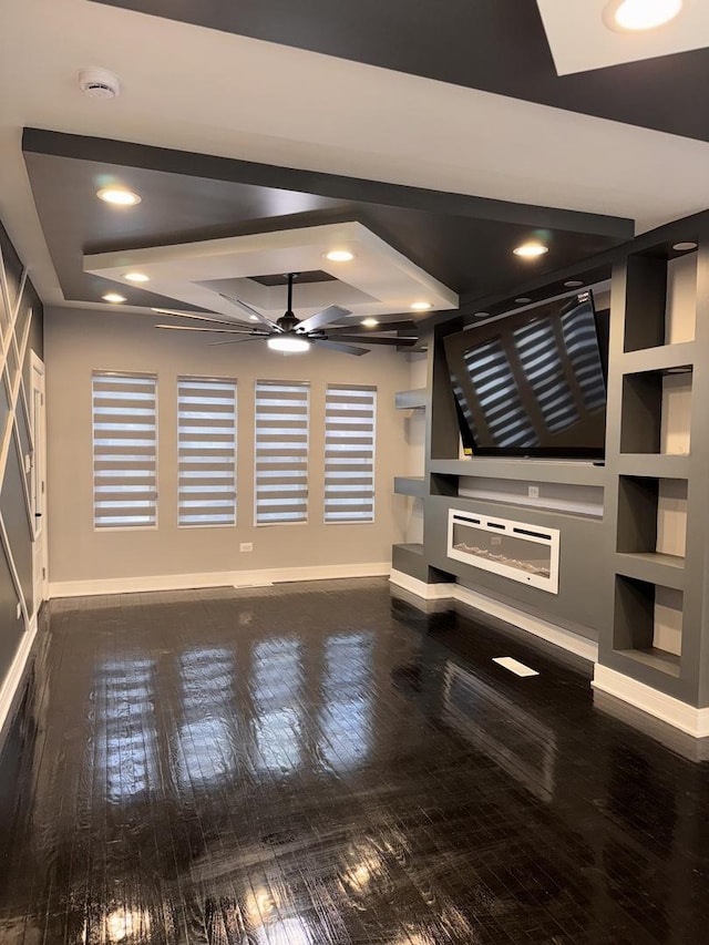 unfurnished living room with built in shelves, ceiling fan, and wood-type flooring