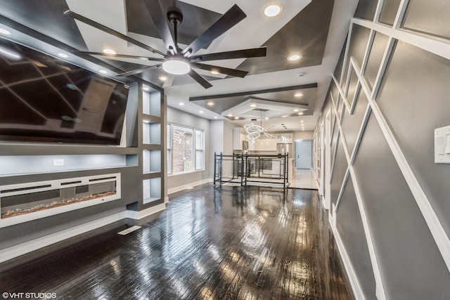 interior space with ceiling fan with notable chandelier and dark wood-type flooring