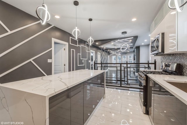 kitchen featuring light stone countertops, stainless steel appliances, tasteful backsplash, decorative light fixtures, and white cabinets