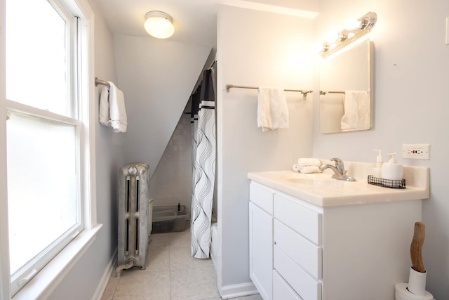 bathroom with vanity, a wealth of natural light, radiator, and tile patterned flooring