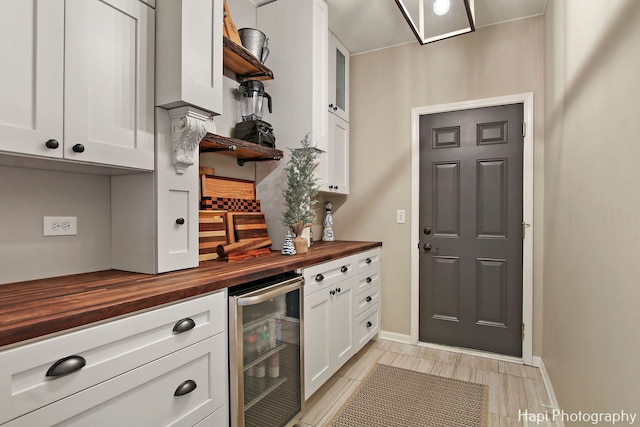 kitchen featuring white cabinets, wine cooler, and wooden counters