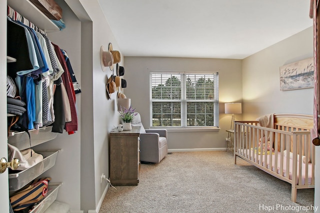 carpeted bedroom featuring a crib