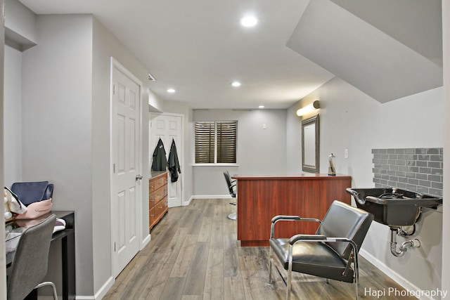 kitchen featuring kitchen peninsula, hardwood / wood-style flooring, and tasteful backsplash