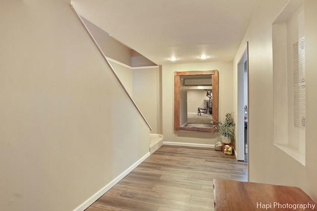 corridor with hardwood / wood-style flooring