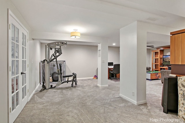 workout room featuring light colored carpet and french doors