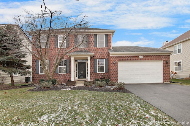 view of front of house with cooling unit, a garage, and a front lawn