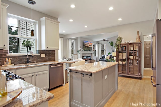 kitchen featuring white cabinets, a kitchen island, sink, and stainless steel appliances