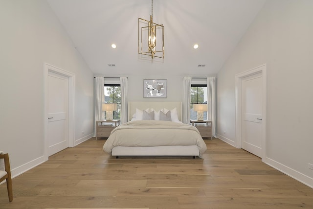 bedroom featuring multiple windows, light hardwood / wood-style floors, and a chandelier