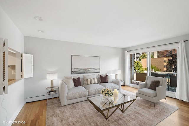 living room featuring light wood-type flooring and a baseboard heating unit