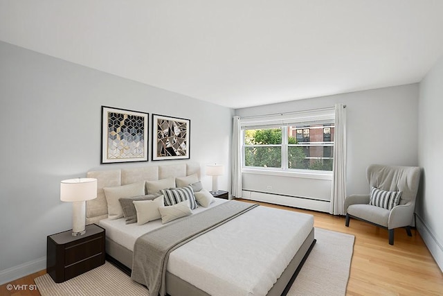 bedroom featuring light wood-type flooring and a baseboard radiator