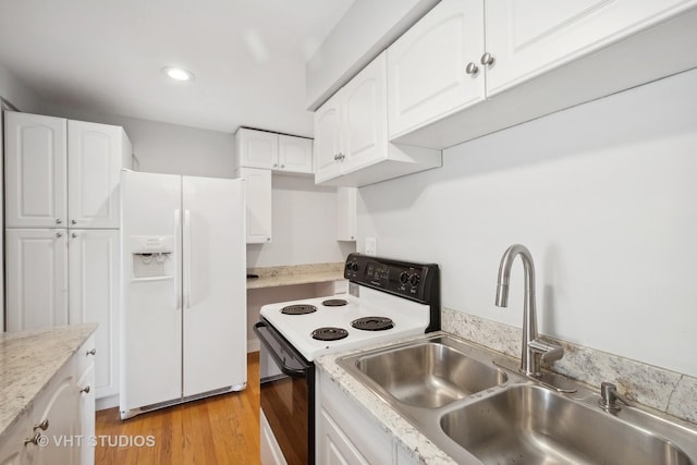 kitchen with white cabinets, white appliances, sink, and light hardwood / wood-style flooring