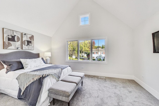 carpeted bedroom with high vaulted ceiling