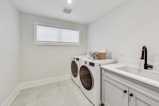 laundry room with cabinets, washing machine and dryer, and sink