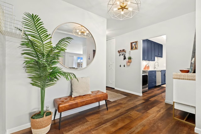 foyer with sink, a chandelier, and dark wood-type flooring