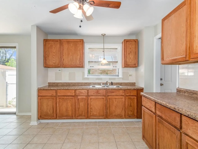 kitchen featuring pendant lighting, ceiling fan, light tile patterned flooring, and sink