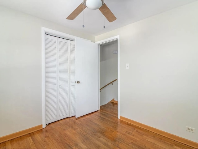 unfurnished bedroom with a closet, ceiling fan, and hardwood / wood-style flooring