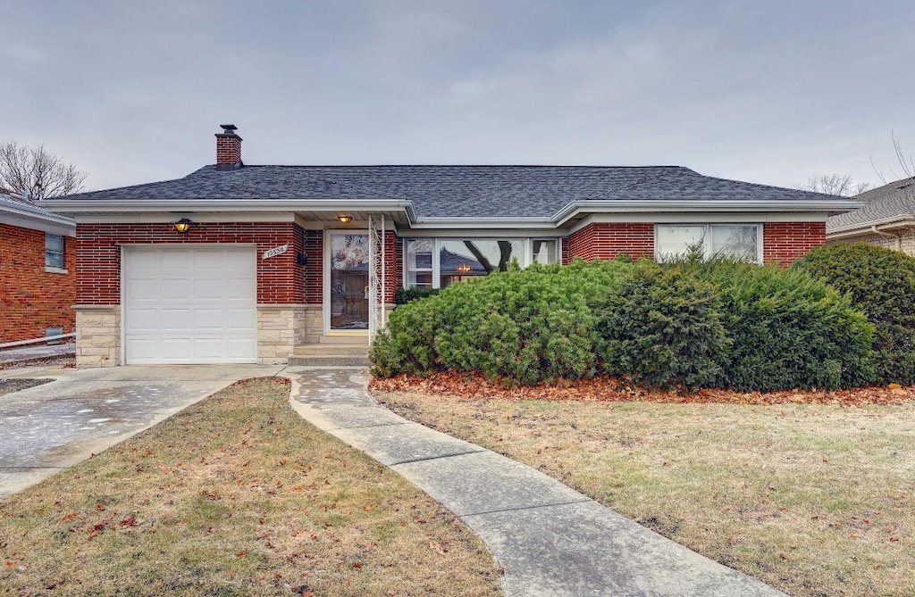 view of front of property with a front yard and a garage