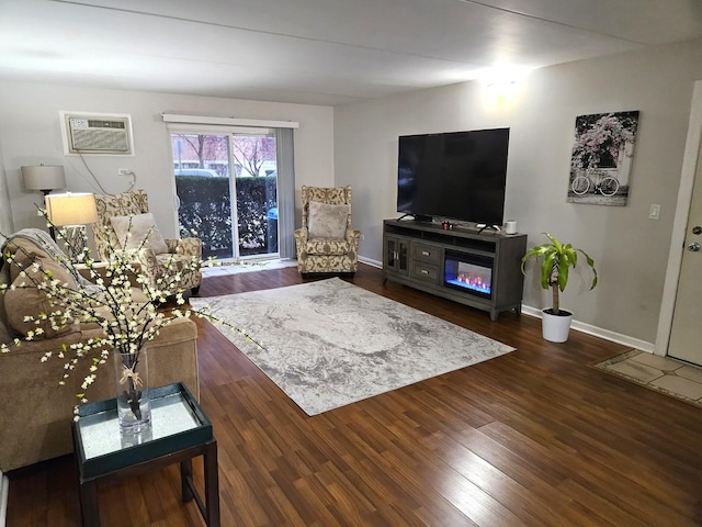 living room featuring an AC wall unit and dark wood-type flooring