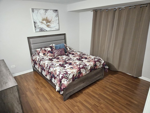 bedroom with dark hardwood / wood-style floors