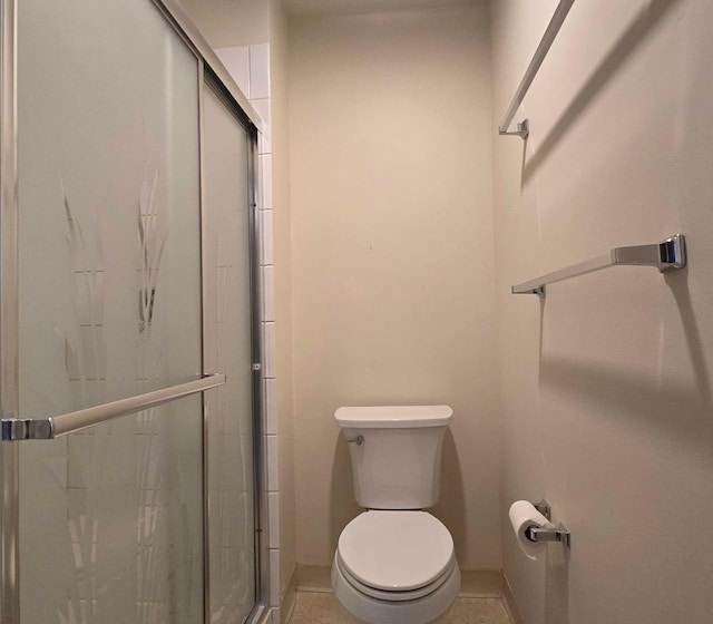 bathroom with tile patterned floors, toilet, and walk in shower