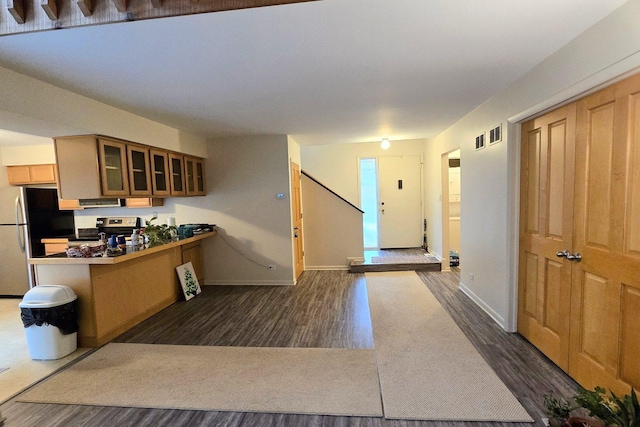 kitchen with a kitchen breakfast bar, dark hardwood / wood-style flooring, kitchen peninsula, and stainless steel appliances